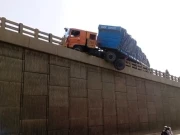 شیر شاہ میں ہیوی ٹرالر بےقابو ہوکر برج کی دیوار توڑ کر لٹک گیا